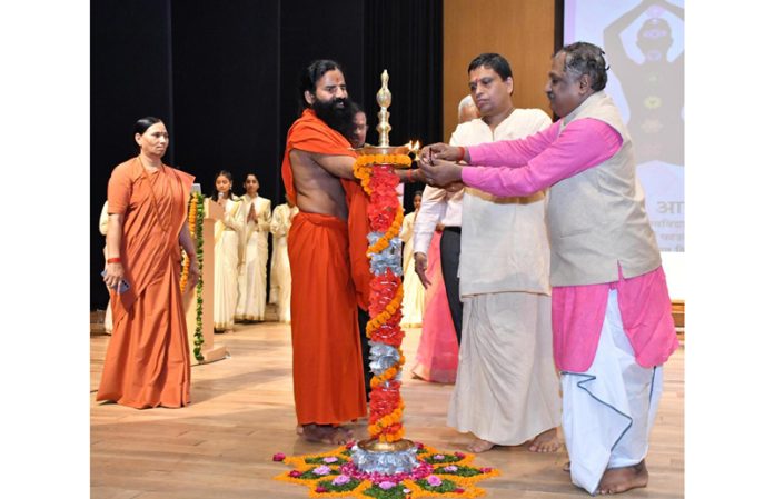 Swami Ramdev of Patanjali Yogpeeth lighting ceremonial lamp to inaugurate a conference at Haridwar on Saturday.