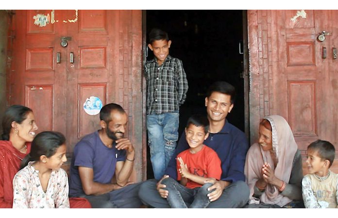 Army doctor serving in Duggan along with smiling poor family of young boy Akshay Sharma after he learns to speak.