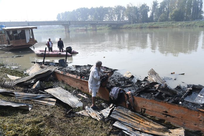 A houseboat caught fire on the Jhelum river near Abdullah bridge in Srinagar earlier on Wednesday morning. Excelsior/Shakeel