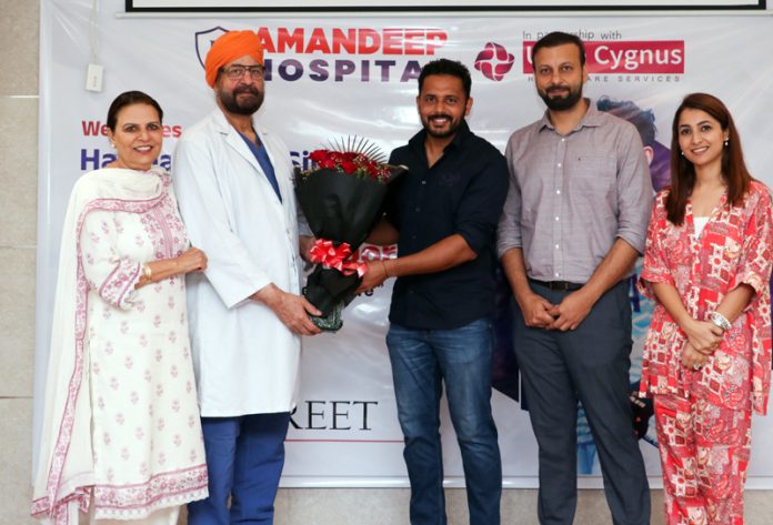 Director Amandeep Hospitals & Ujala Cygnus, Dr Avtar Singh, presenting a bouquet to Indian Hockey Captain Harmanpreet Singh.