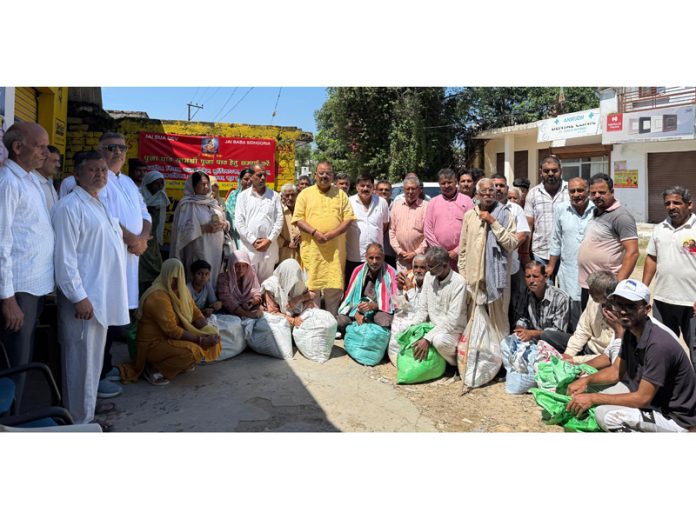 Former Minister and MLA, Vijaypur Chander Parkash Ganga distributing relief among flood hit people in Purmandal on Saturday.