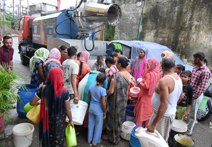 People collect water from a JMC vehicle in Jammu on Tuesday as the city reels under severe water crisis. -Excelsior/Rakesh