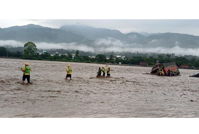 SDRF personnel rescuing a stranded vehicle as the Chandrabhaga river flows in spate due to heavy rains in Rishikesh. SDRF personnel rescuing a stranded vehicle as the Chandrabhaga river flows in spate due to heavy rains in Rishikesh.