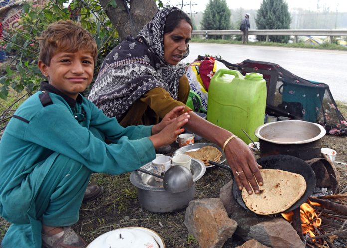 Displaced by floods, a nomadic family sets up a makeshift home along the Nowgam Bypass in Srinagar on Friday. —Excelsior/Shakeel Displaced by floods, a nomadic family sets up a makeshift home along the Nowgam Bypass in Srinagar on Friday. —Excelsior/Shakeel