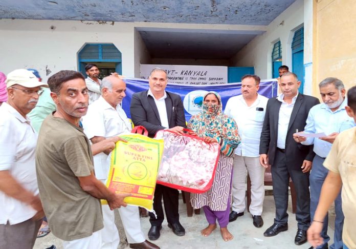 Gurjar Desh Charitable Trust team distributing relief material to flash floods hit families in Dansal Block of Jammu on Tuesday.