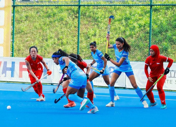 Players in action during a hockey match between India and Singapore.