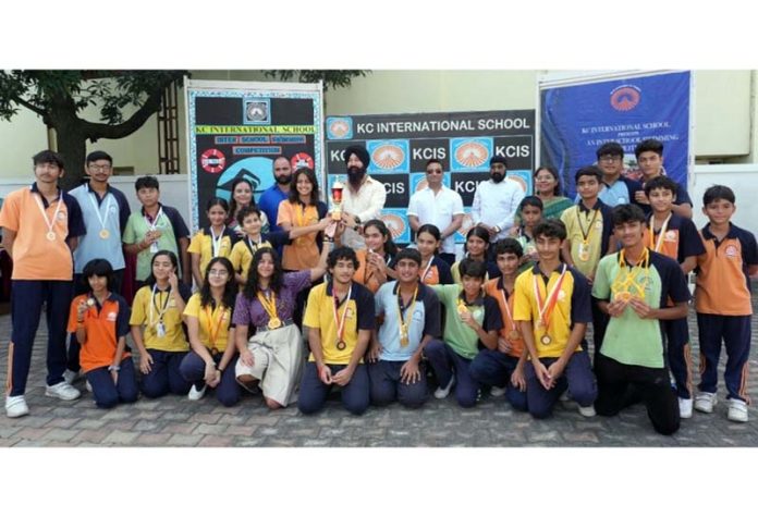 Winners pose with their medals and a trophy during prize distribution ceremony.