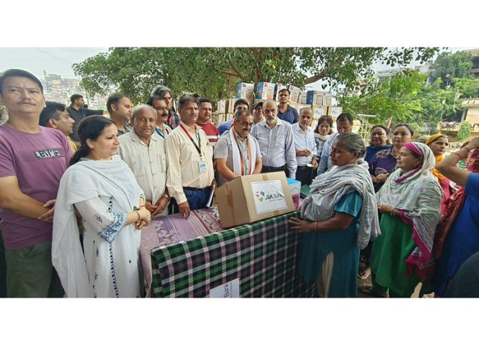 J&K Bank staff distributing flood relief kits to people in Jammu . J&K Bank staff distributing flood relief kits to people in Jammu .