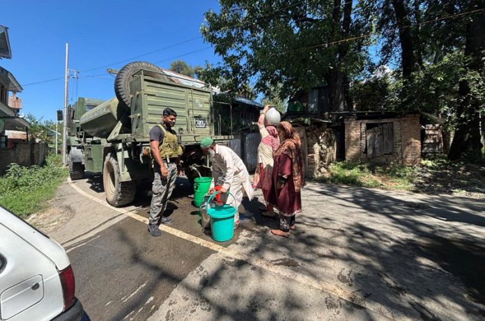 People filling water in their buckets from an Army tanker in south Kashmir's Anantnag district on Monday. —Excelsior/Sajad Dar