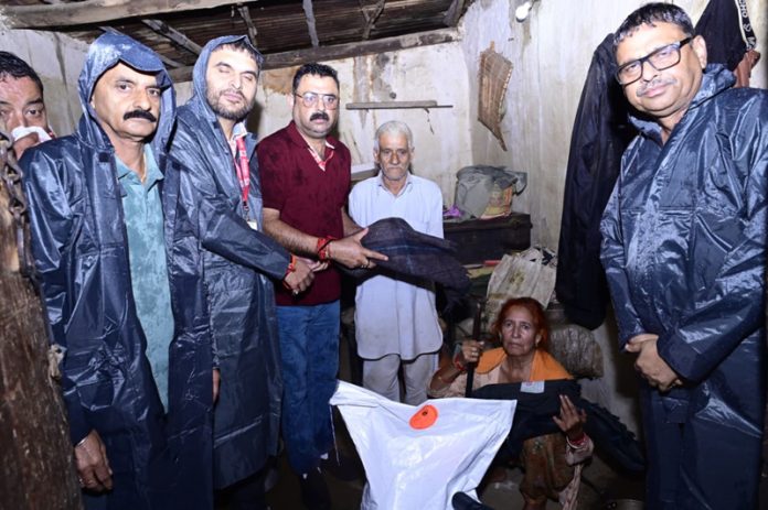SMVDSB officials providing relief material to a rain-hit family in Reasi district.