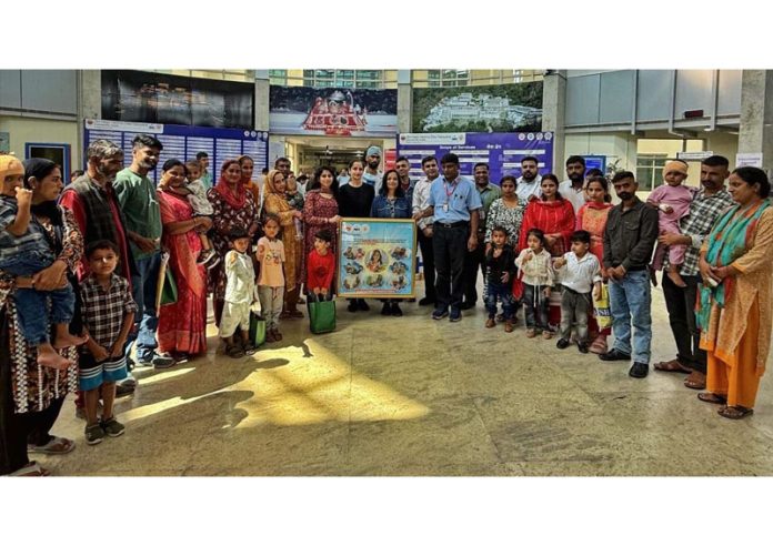 Recipients of cochlear implants and their families posing with philanthropist Deepali Chawla and others at Narayana Hospital, Katra.