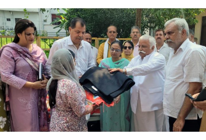Senior NC leader Ajay Kumar Sadhotra distributing relief material in Janipur area of Jammu.