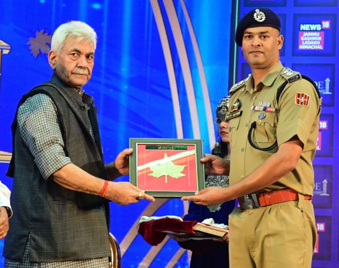 LG felicitating a JKP officer at Srinagar on Saturday.