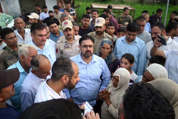 Minister Satish Sharma interacting with flood affected people on Sunday.