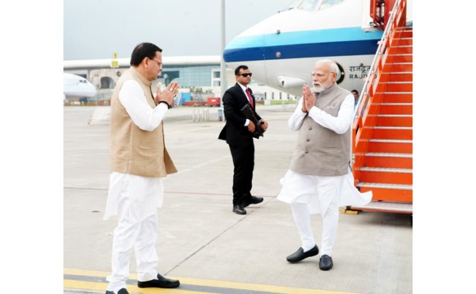 CM Dhami receiving PM Modi, after he reached at the Jolly Grant airport at Dehradun.