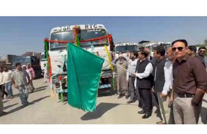 Minister Satish Sharma flagging off fruit-laden trucks of JKRTC to national markets on Sunday.