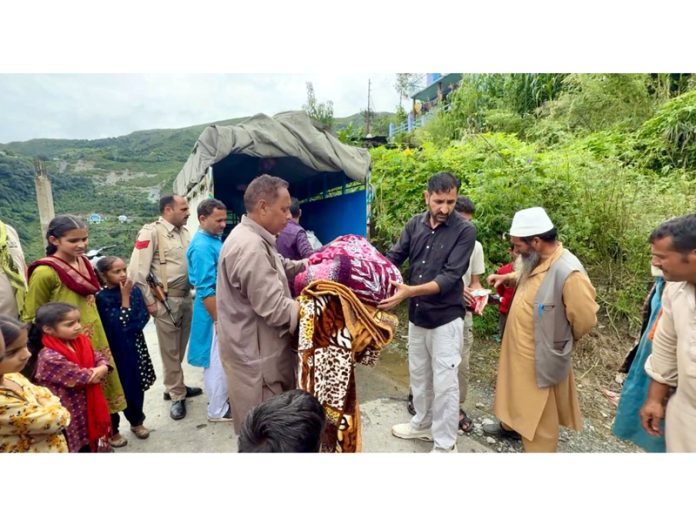 MLA Dr Rameshwar Singh distributing relief material among the flood affected people in Bani. MLA Dr Rameshwar Singh distributing relief material among the flood affected people in Bani.