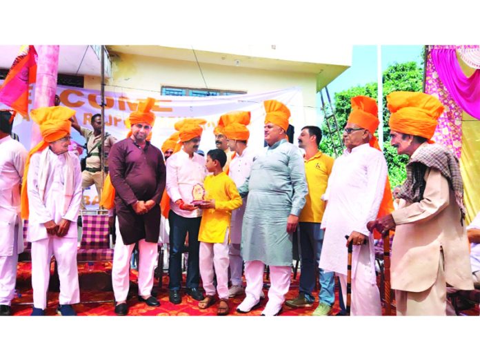 MLA Billawar Satish Sharma felicitating a meritorious student during an event by Amar Kshatriya Rajput Sabha at Billawar.