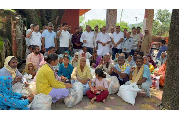 MLA Vijaypur C P Ganga distributing ration among flood hit victims of Vijaypur villages on Wednesday.