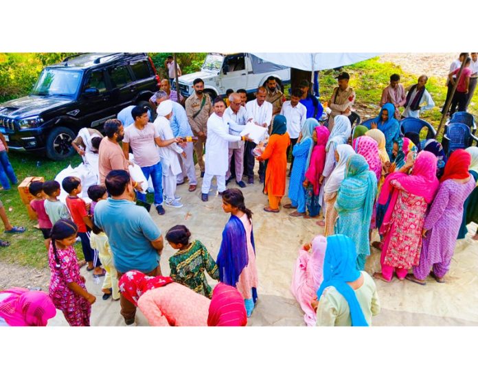 MLA Kathua, Bharat Bushan distributing relief material among cloudburst hit people in Kathua villages on Friday.