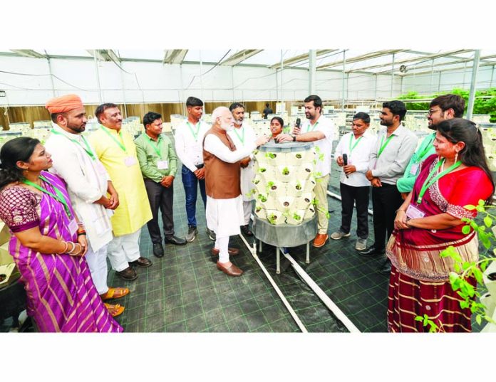Prime Minister Narendra Modi interacting with farmers at Pusa in New Delhi on Saturday.(UNI)