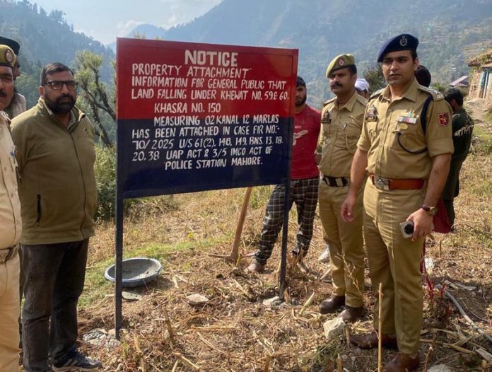 Police attaching immovable property of a Pak based terror operative in Mahore on Wednesday.