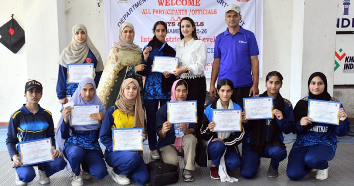Winners in various categories of fencing competition posing together while displaying their certificates.