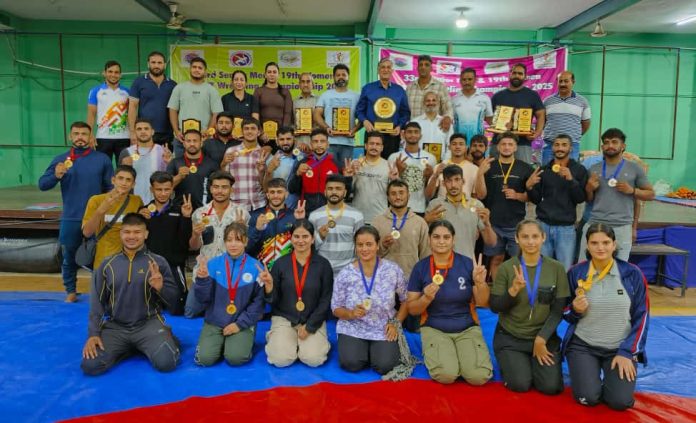 Wrestlers posing along with dignitaries during prize distribution ceremony.