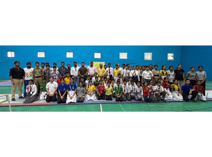 Medal winners posing along with dignitaries during prize distribution ceremony.