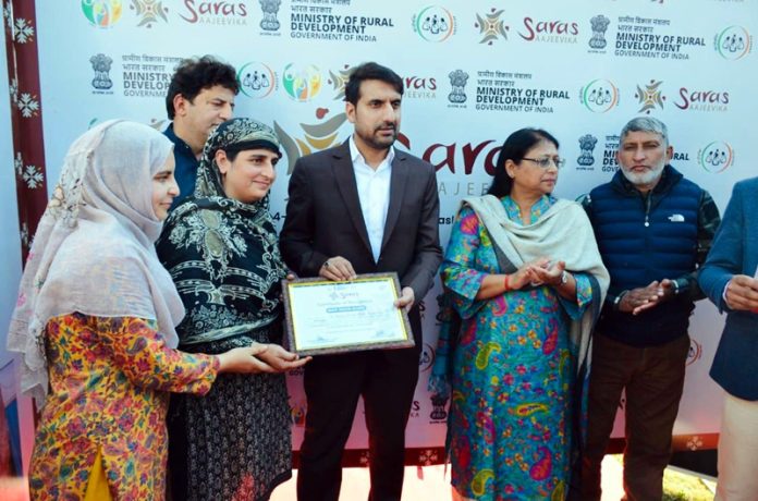 Secretary RDD presenting certificate to a woman on Tuesday.