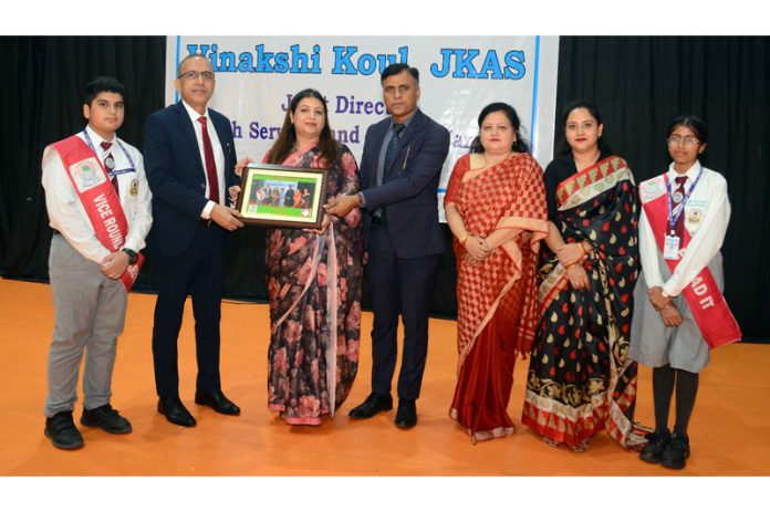 School management presenting memento to chief guest during a programme.