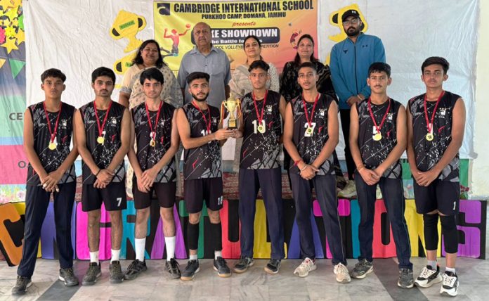 Winning team posing along with trophy.