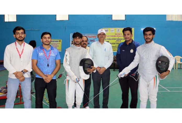 Fencers posing along with dignitaries before start of match.
