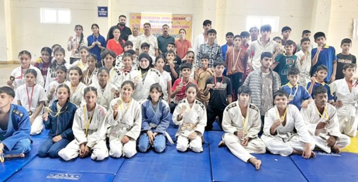 Medal winner judo athletes posing along dignitaries.