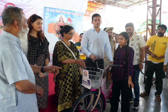 DC Jammu, Dr Rakesh Minhas and SDM Marh, Pallavi besides representatives of Sewa Bharti distributing cycles among girl children at Marh on Friday.