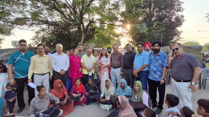 Dignitaries from Rotary Clubs along with MLA Vikram Randhawa and others posing for a photograph after distributing relief material to flood hit people in Jammu on Thursday.