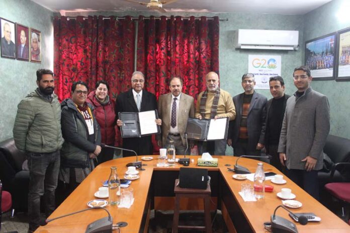 IUST Vice Chancellor Prof Shakil A Romshoo and President, Kashmir Care Foundation, Dr Altaf Lal display copies of MoU signed by them.
