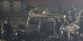 Officers from various security agencies investigate the spot after a blast occurred in a parked car near Red Fort, leaving multiple vehicles in flames, in New Delhi.