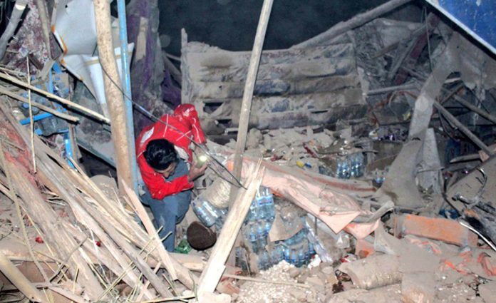 A rescuer works at a quake-hit site in northern Afghanistan on Monday. (UNI)