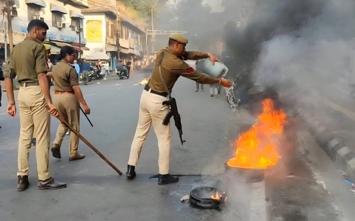 Police personnel trying to douse the flames arising out of burnt tyres at Gummat on Saturday.