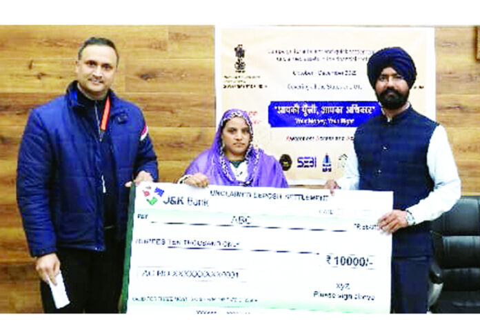 DC Doda handing over a cheque to a beneficiary in the town on Friday.
