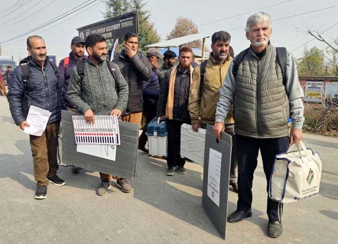 Polling staff leave with EVMs for designated stations ahead of Budgam bypoll on Monday. -Excelsior/Shakeel