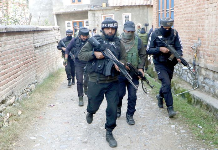 Police during raids at Larkipora, Anantnag on Wednesday.