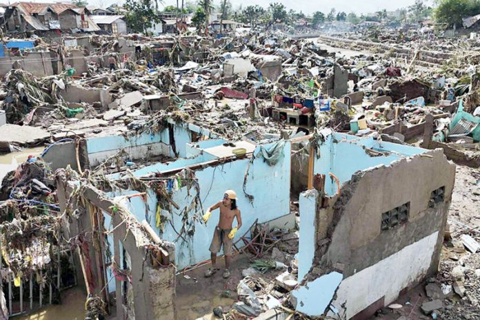 A resident returns to what remains of his home after Typhoon Kalmaegi devastated communities along the Mananga River in Talisay City, Cebu province, central Philippines on Wednesday.
