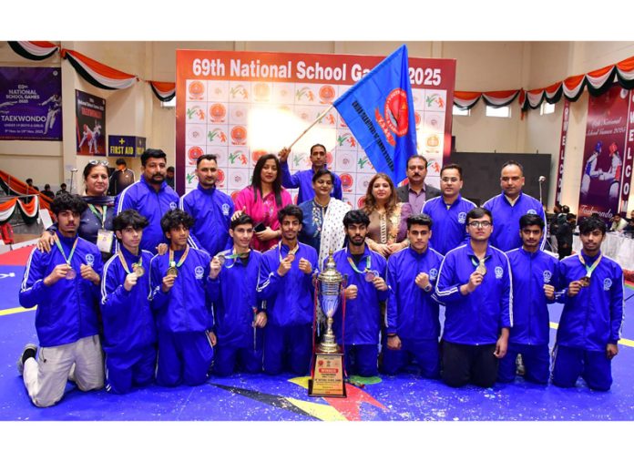 Winning team posing along with trophy.