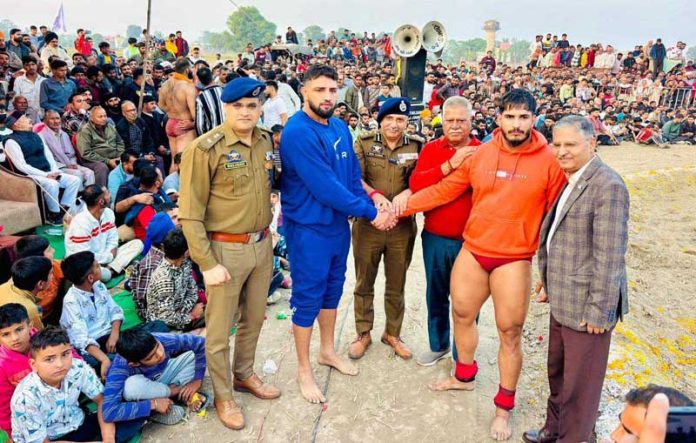 Dignitaries posing along with wrestlers.