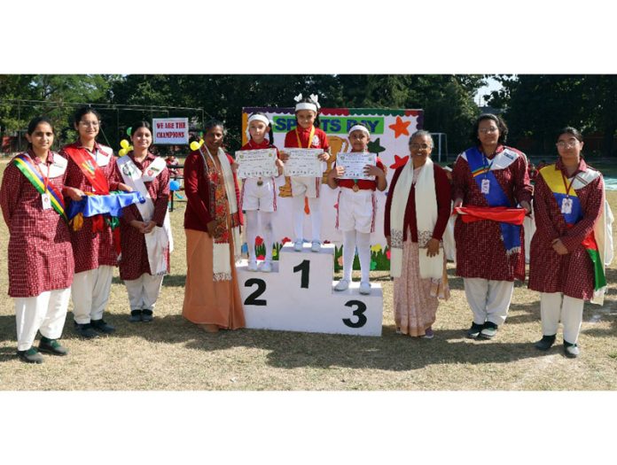 Students on the podium posing with teaching staff.