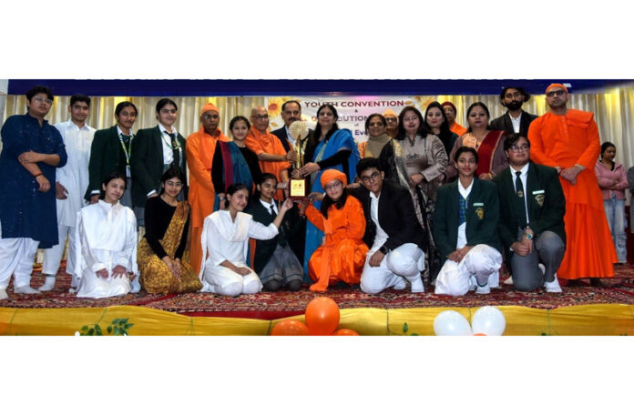 Dignitaries and students posing along with trophy during a programme.