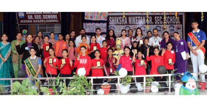 Students posing along with school management during a programme. Students posing along with school management during a programme.