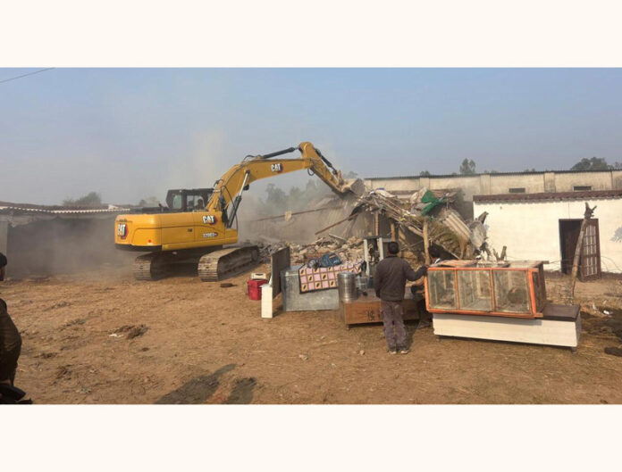 Illegal structure on encroached land being demolished in Bishnah area on Friday.